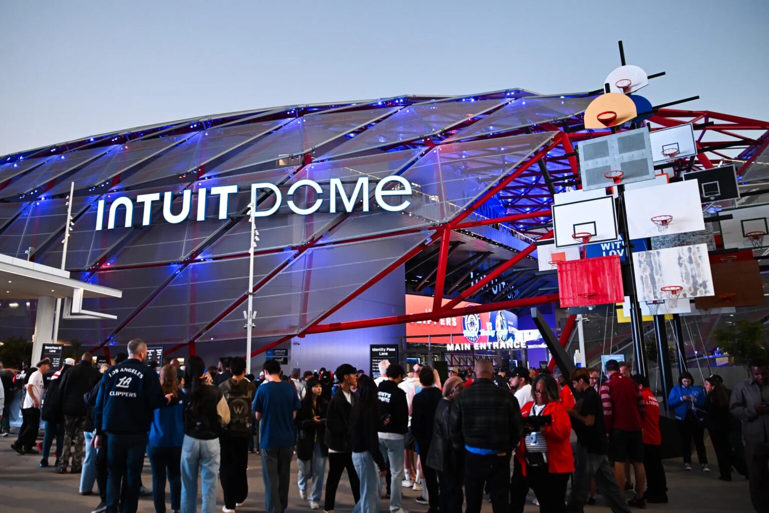 Stadium exterior with crowds of people at the entrance, waiting in line to buy their favorite merchandise, highlighting a high-traffic sports venue.